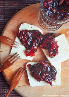 two pieces of bread with jam on them and some utensils next to it