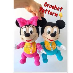 two crocheted mickey and minnie mouse dolls are being held by someone's hand