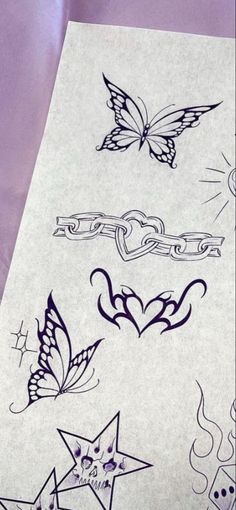 some tattoos that are on the side of a sheet of paper with butterflies and stars