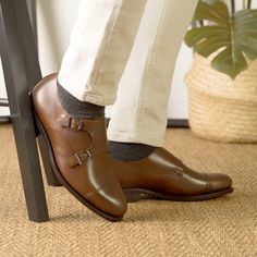 a person wearing brown shoes and white pants