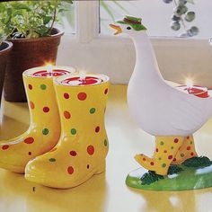 a pair of yellow boots sitting on top of a table next to a white duck