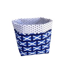 a blue and white basket with polka dots on the bottom, sitting in front of a white background