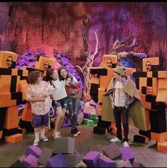 some people are standing in front of an art display with purple and orange cubes