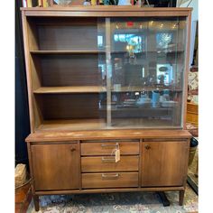 a wooden cabinet with glass doors and drawers