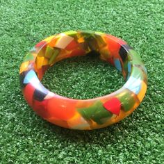 "1930s End Of The Day Confetti Lucite Multicolour Bangle. This vibrant and stunning piece  one of the most remarkable we have found.  Undeniably unique,  the bangle has weight and substance  A beautiful mix of bright colours  and is in outstanding vintage condition.  The wearable diameter is 2 1/2 inches,  The complete piece is 3 1/2 inches diameter.  The bangle measure 7/8 of an inch wide . This is a great collectible bangle. Would make a great gift . A true One Off!  Developed in the 1930s, th Retro Handmade Bangle Jewelry, Retro Multicolor Bracelet Jewelry, Retro Multicolor Round Jewelry, Multicolor Round Retro Jewelry, Handmade Retro Bangle Bracelet, Retro Multicolor Bracelets For Gift, Retro Multicolor Bangle Jewelry, Multicolor Retro Bracelets For Gift, Multicolor Retro Bracelet For Gift