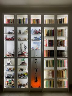 there are many bookshelves in the room with toy boats on them, and one is lit up