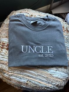 an uncle t - shirt sitting on top of a bed