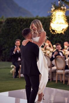 the bride and groom are dancing together at their wedding reception in front of an audience