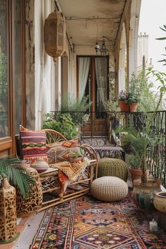 an outdoor porch with lots of plants and wicker furniture