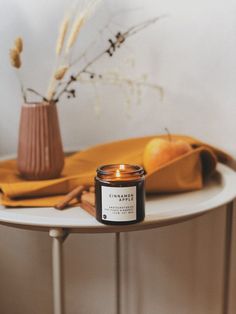 a candle sitting on top of a table next to an orange