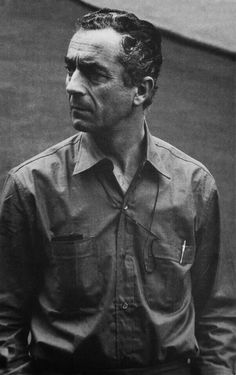 an old black and white photo of a man in a button up shirt looking off to the side