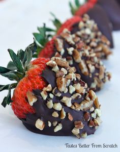 three chocolate covered strawberries with nuts on them