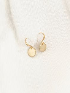 HARU GOLD DISC EARRINGS * MATTE GOLD DOT EARRINGS HARU is a Japanese name that means sun or sunlight. Everyone can use a drop of sunshine in their wardrobe! These dainty matte gold drop earrings catch light perfectly as they dangle from your ears. Well suited for everyday wear with any outfit or event. Both simple and classic, these dainty gold dot earrings would be a great gift for any occasion. SIZE Total length: 22mm Disc Size: 10mm MATERIALS Gold Disc- Fine gold plated | brass French Ear Loo Tarnish Resistant Round Disc Earrings As Gift, Gold Circle Earrings 14k Gold Filled, Gold Round Disc Earrings For Everyday, Tarnish Resistant Circular Earrings As Gift, Tarnish Resistant Circular Earrings For Gifts, Round Tarnish Resistant Earrings For Gift, 14k Gold Circle Earrings For Gifts, Dainty Round Disc Earrings For Everyday, Gold Round Disc Earrings For Pierced Ears