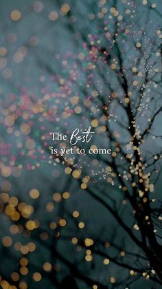 the best is yet to come with blurry lights in the background and tree branches