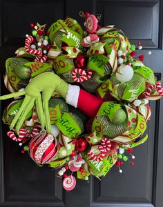 a christmas wreath with an elf's hand and candy canes on the front door