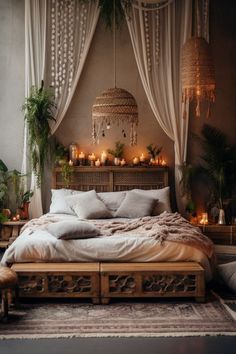 a large bed sitting in a bedroom next to a table with candles on it and plants