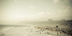 many people are on the beach and in the water