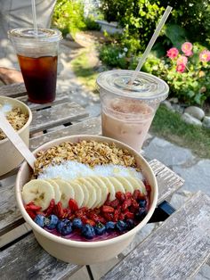 a bowl of fruit and granola on a picnic table