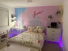 a bed room with a neatly made bed next to a desk and dressers in front of a colorful wall