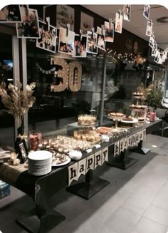 a long table filled with lots of food on top of a black and white floor