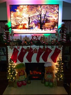 a christmas fireplace decorated with stockings and teddy bears