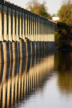 a large bridge spanning over a body of water with trees in the backgroud