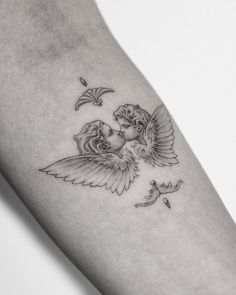 a woman's arm with an angel tattoo on the left side of her body