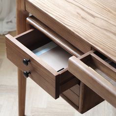 an open drawer on a wooden desk with drawers