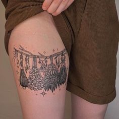 a woman's thigh with tattoos on it