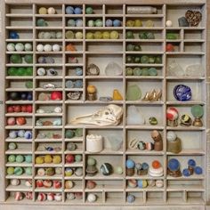 a shelf filled with lots of different types of vases and pottery on top of wooden shelves