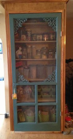 an old china cabinet is painted teal and has glass doors that open to reveal the pantry