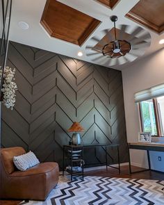 a living room with an area rug and ceiling fan