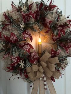 a christmas wreath with a lit candle in it