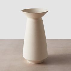 a white vase sitting on top of a table