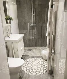 a white toilet sitting in a bathroom next to a walk - in shower and sink