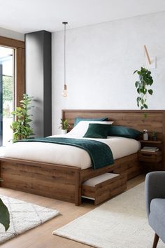 a large bed sitting next to a window on top of a hard wood flooring