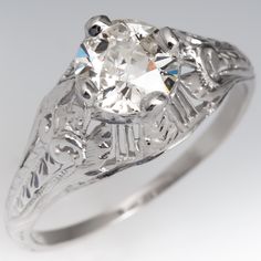 Circa 1930s ring features a domed pierced design and accented with engraved wheat details. The ring is centered with one (1) old European cut diamond set into four-prong head. The ring measures 8.8mm at the top, rises 6.2mm above the finger, tapering to 1.2mm wide and 0.8mm thick at the base of the shank. Luxury Antique Silver Diamond Ring, Vintage Oval Diamond Filigree Ring, Vintage Oval Diamond Ring With Filigree, Vintage Diamond Filigree Ring, Classic Oval Engraved Ring With Filigree, Vintage Oval Diamond Cut Wedding Ring, Vintage Platinum Jewelry With Single Diamond, Vintage Engraved Ring With Single Diamond For Formal Occasions, Vintage Platinum Wedding Ring With Single Diamond