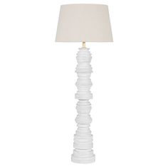 a white lamp with a beige shade on it