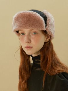 a woman with long red hair wearing a fur hat