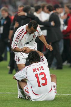 two soccer players sitting on the ground during a game