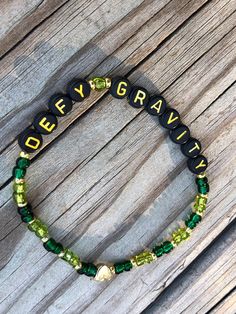 Defy Gravity Wicked Bracelet! A beautiful reminder of an amazing moment in "Wicked".  Share and remember each moment! The perfect gift to compliment tickets to a show, a gift for a fan to enjoy, or a celebration of an upcoming performance by a friend in a show! So many reasons to Share, Sparkle and SHINE!  A portion of the proceeds from Broadway Bracelets sold by The Gift Shop by TCS will be donated to BROADWAY CARES!  "Broadway Cares/Equity Fights AIDS is the philanthropic heart of Broadway, helping people across the country and across the street receive lifesaving medications, health care, nutritious meals, counseling and emergency financial assistance." Handmade Friendship Bracelet! Elastic, 7.5, please write us for custom requests! My daughter and I enjoy wearing, and making these brac Wicked Bracelet Ideas, Wicked Friendship Bracelet, Fandom Beaded Bracelets, Beetlejuice Beaded Bracelet, Wicked Musical Bracelet, Wizard Of Oz Bracelet, Handmade Friendship Bracelets, Bracelet Kits, Friendship Bracelets Designs