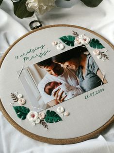 an embroidered photo frame with flowers and leaves