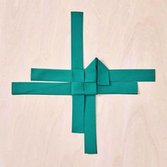 an origami cross made out of green paper