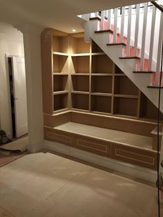 an empty room with some shelves and stairs