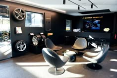 the interior of a car showroom with several chairs and wheels on display in it