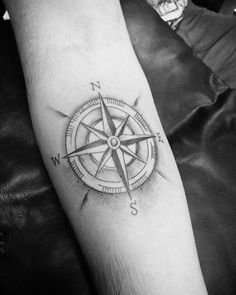 a black and white photo of a compass tattoo