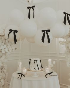 a table topped with white and black balloons