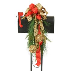 a mailbox decorated with gold and red bows, bells and pine cones for christmas