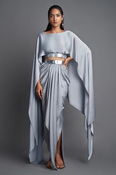 Ice grey metallic cape top with asymmetric hem. Paired with draped skirt.
Component: 2
Pattern: Plain
Neckline: Boat
Sleeve Type: Draped Sleeve
Fabric: Chiffon
Color: Grey
Other Details: 
Asymmetric cape
Draped skirt
Occasion: Resort - Aza Fashions Skirt Drape, Dhoti Skirt, Western Party Wear, Amit Aggarwal, Crop Top Suit, Suit Indian, Ladies Outfits, Cape Top, Skirt Draping