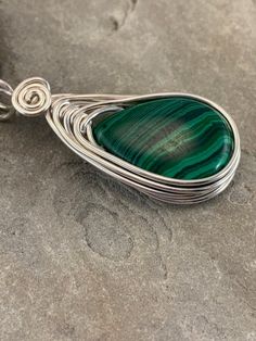 This Malachite necklace is simple yet elegant.  Malachite is a beautiful green color with unique striping/bands of color. I chose to enhance this beautiful smoothstone with a Celtic inspired silver wire design to let the natural beauty of the gemstone shine. This necklace is handmade by me with a synthetic malachite stone The necklace you will receive will be similar to the one in the picture, each stone is unique. The 4th photo in my listing shows the subtle variations of these Beautiful genuin Green Malachite Handmade Necklace, Handmade Green Malachite Necklaces, Handmade Green Malachite Necklace, Green Natural Stone Teardrop Pendant Necklace, Green Adjustable Teardrop Necklaces, Adjustable Teardrop Green Necklace, Green Teardrop Wire Wrapped Necklace, Green Oval Malachite Necklaces, Green Malachite Wire Wrapped Jewelry